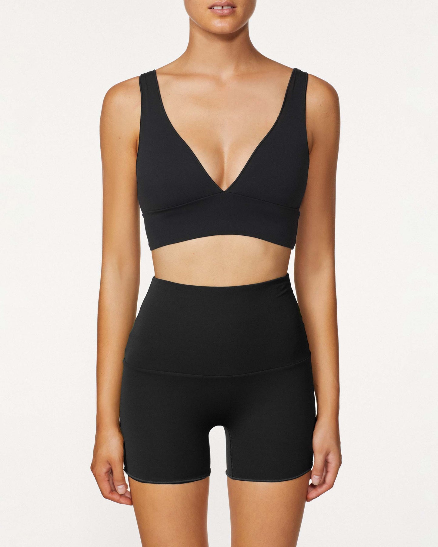 Model wearing the Contour Boy short in black, featuring its high rise waistband and compression fit.