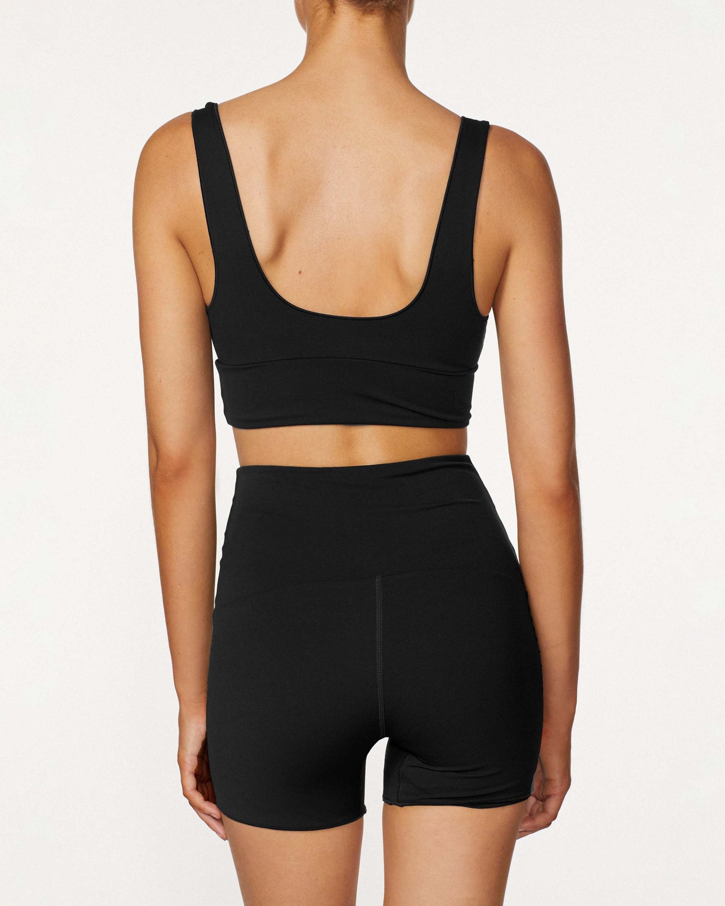 Model wearing the Contour Boy short in black, featuring its high rise waistband and compression fit.