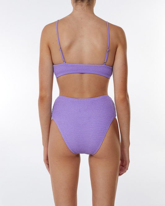 Studio image of model wearing the Waisted Pant in Bloom Crimp, showcasing its medium to cheeky bottom coverage. 