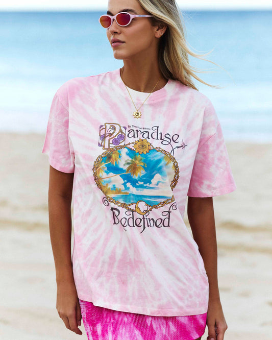 Model posing in front of the ocean while wearing the Signature Tee in Dynamite Paradise.