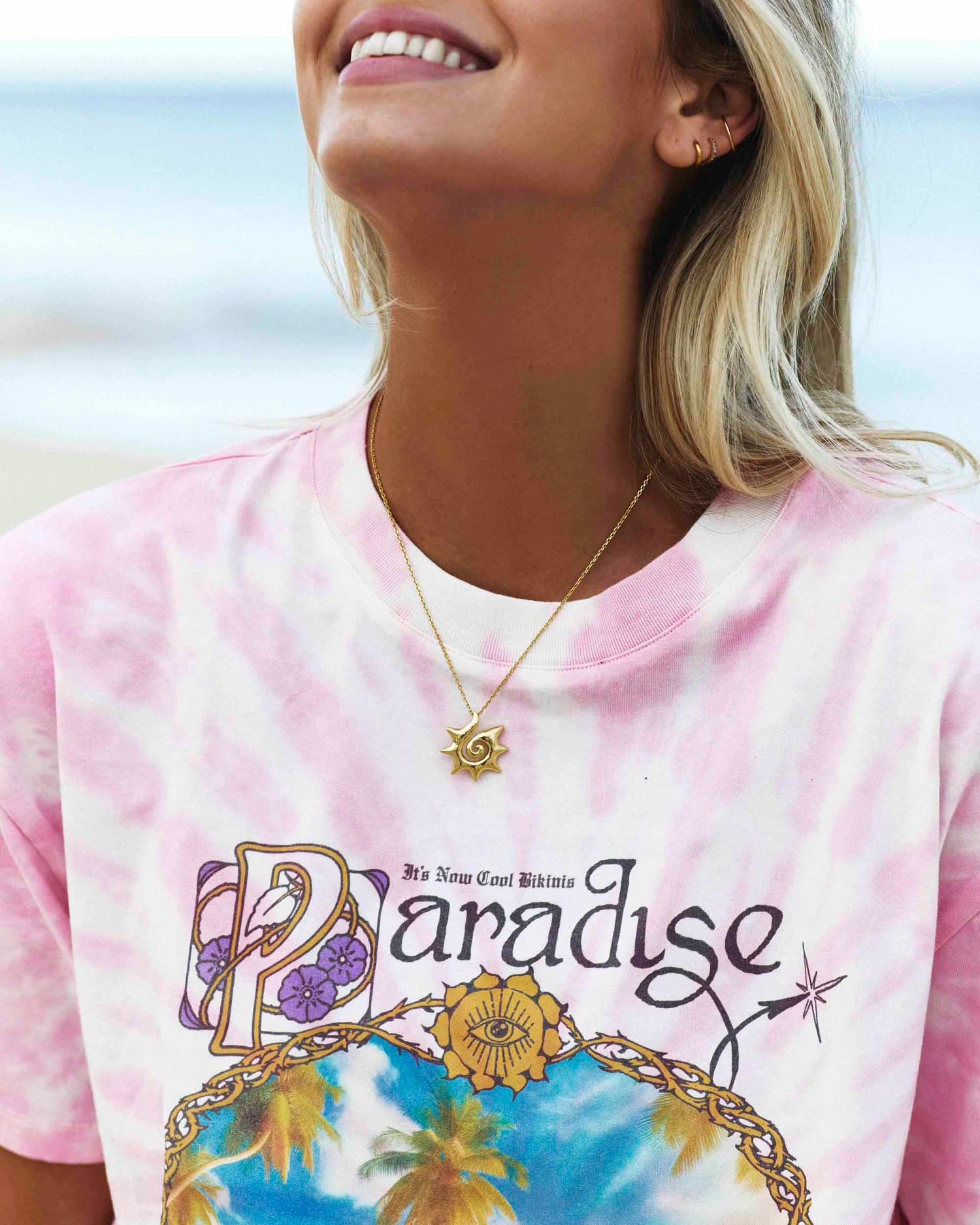 Model posing in the Signature Tee in Dynamite Paradise, highlighting its pink tie-dye design and ribbed neckband.