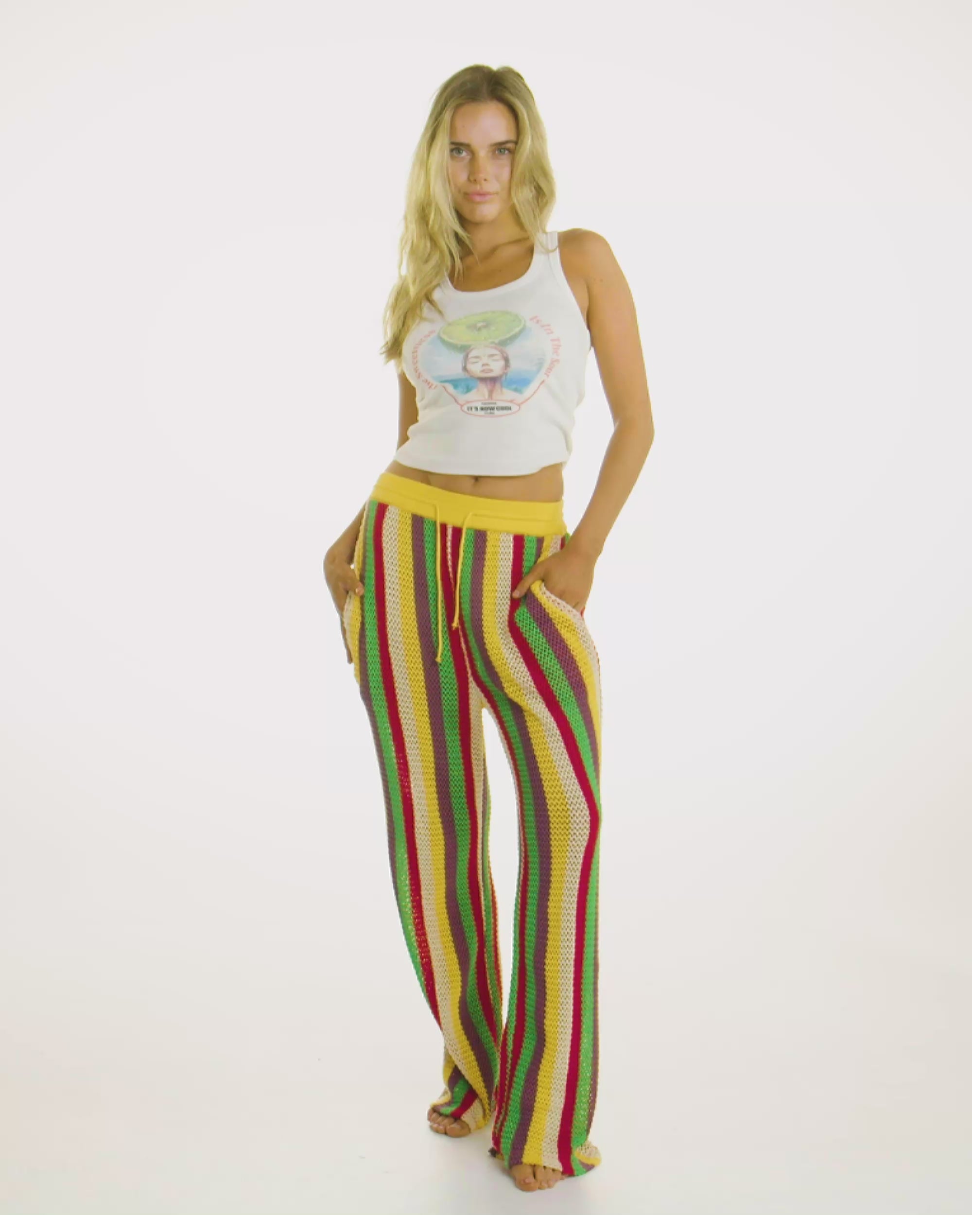 Video of model wearing the Crochet Leisure Pant in Tulum, showcasing its multi-colored crochet striped design. 