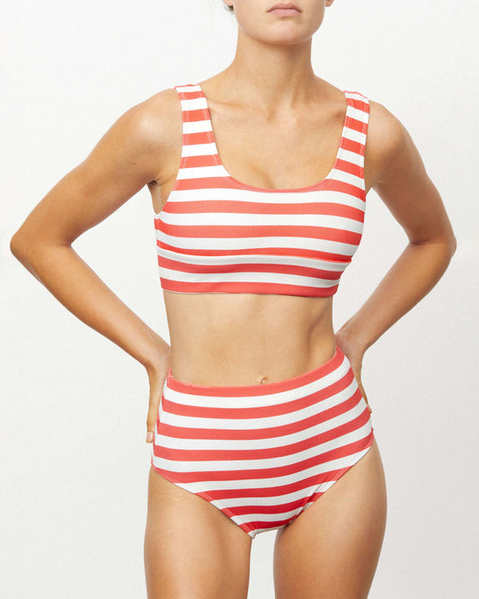 Studio image of model wearing the Banded Pant in Haleiwa, featuring its red and white striped print. 
